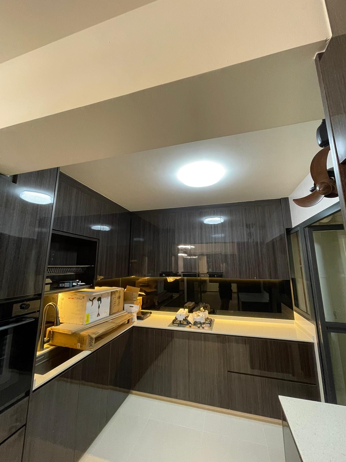 After transformation: open concept living area with custom oak cabinetry and ambient cove lighting